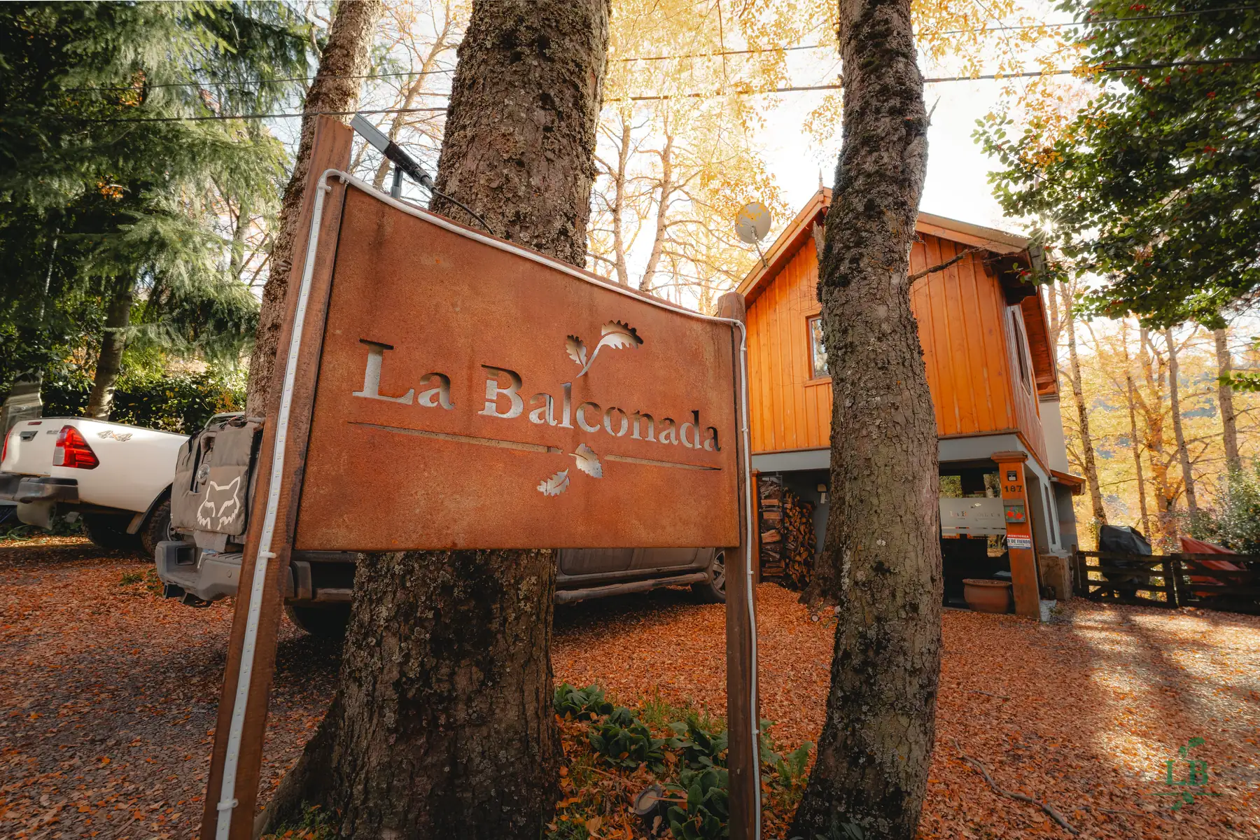 Cartel de La Balconada entre los árboles en otoño